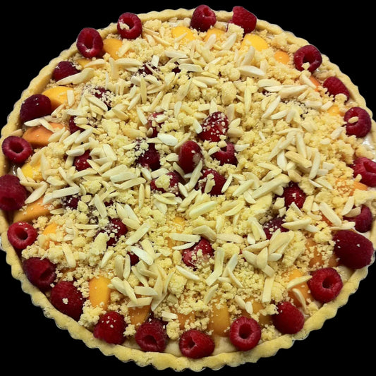 Unbaked tart with fruit and crumb topping on a metal surface