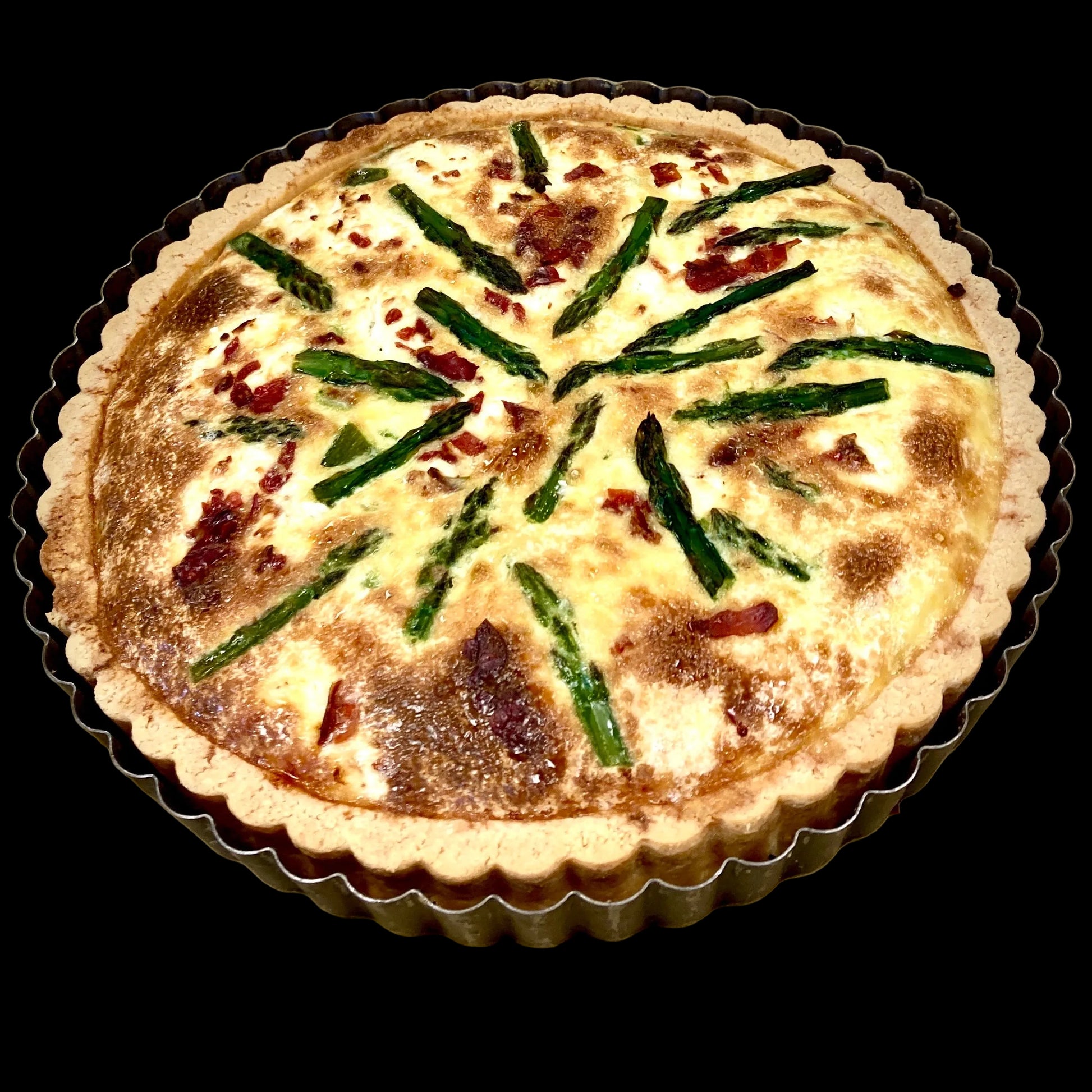 asparagus and prosciutto tart on a baking mold 