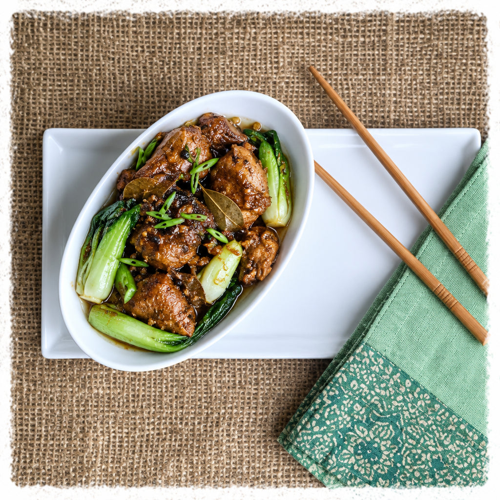 Filipino adobo style chicken thigh slow braised with onion, garlic, black pepper, bay leaf, soy sauce, coconut milk and vinegar.